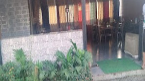 A building with a brick facade, a gravel driveway, and a green mat at the entrance. - Renuka Executive (Rajgurunagar)