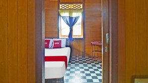 A room with a bed, a small table, and a window with curtains.