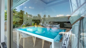 A glass-enclosed dining area with a pool table, dining set, and a view of a tropical landscape. - 3BR Villa Mikia SDV007 By Samui Dream Villas (maenam)