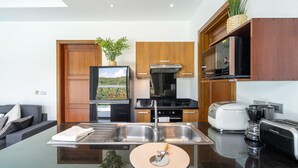 A modern kitchen with a central island, stainless steel appliances, and wooden cabinetry. - 3BR Villa Mikia SDV007 By Samui Dream Villas (maenam)