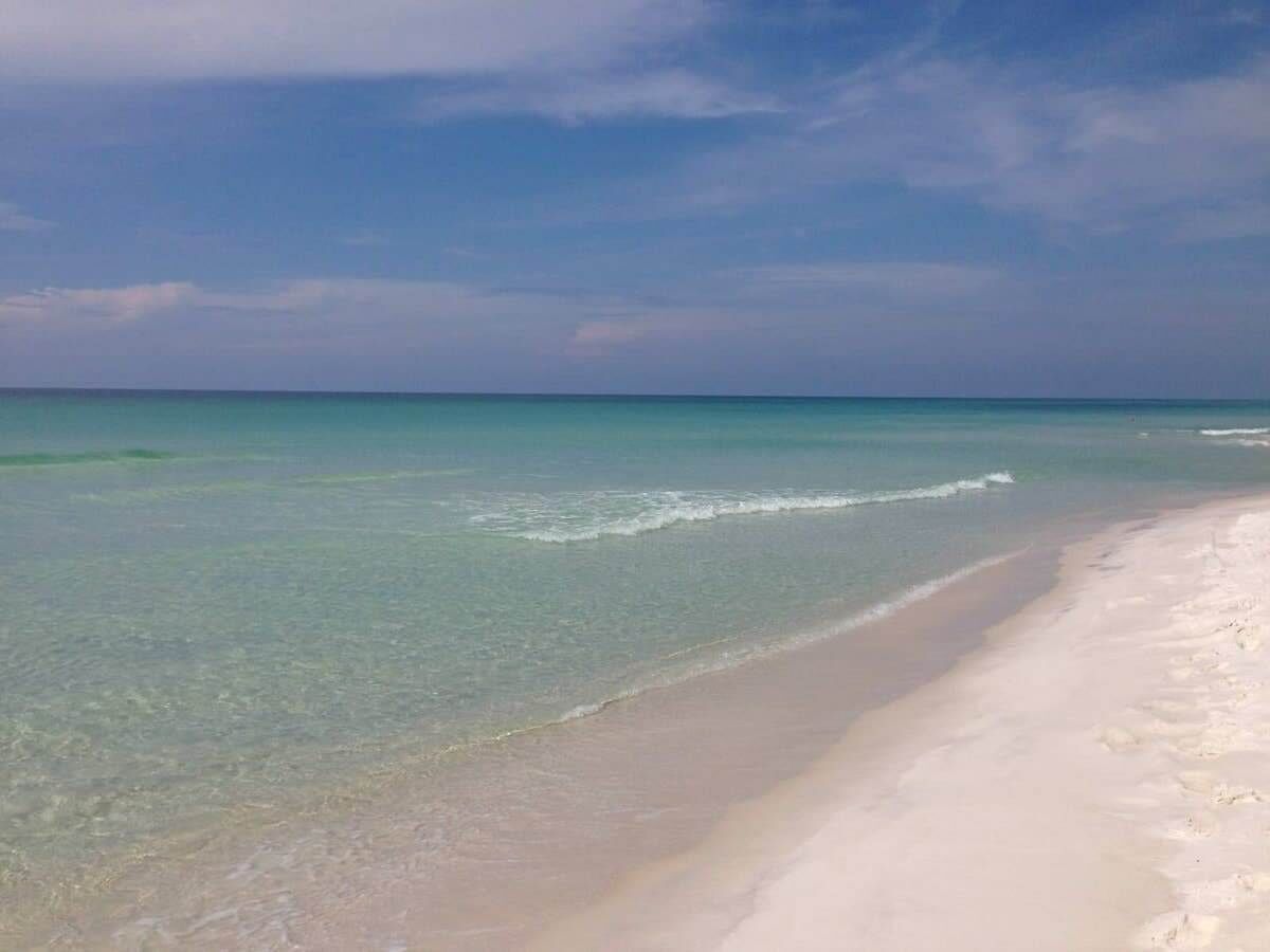 A beach with clear turquoise water and a sandy shore.