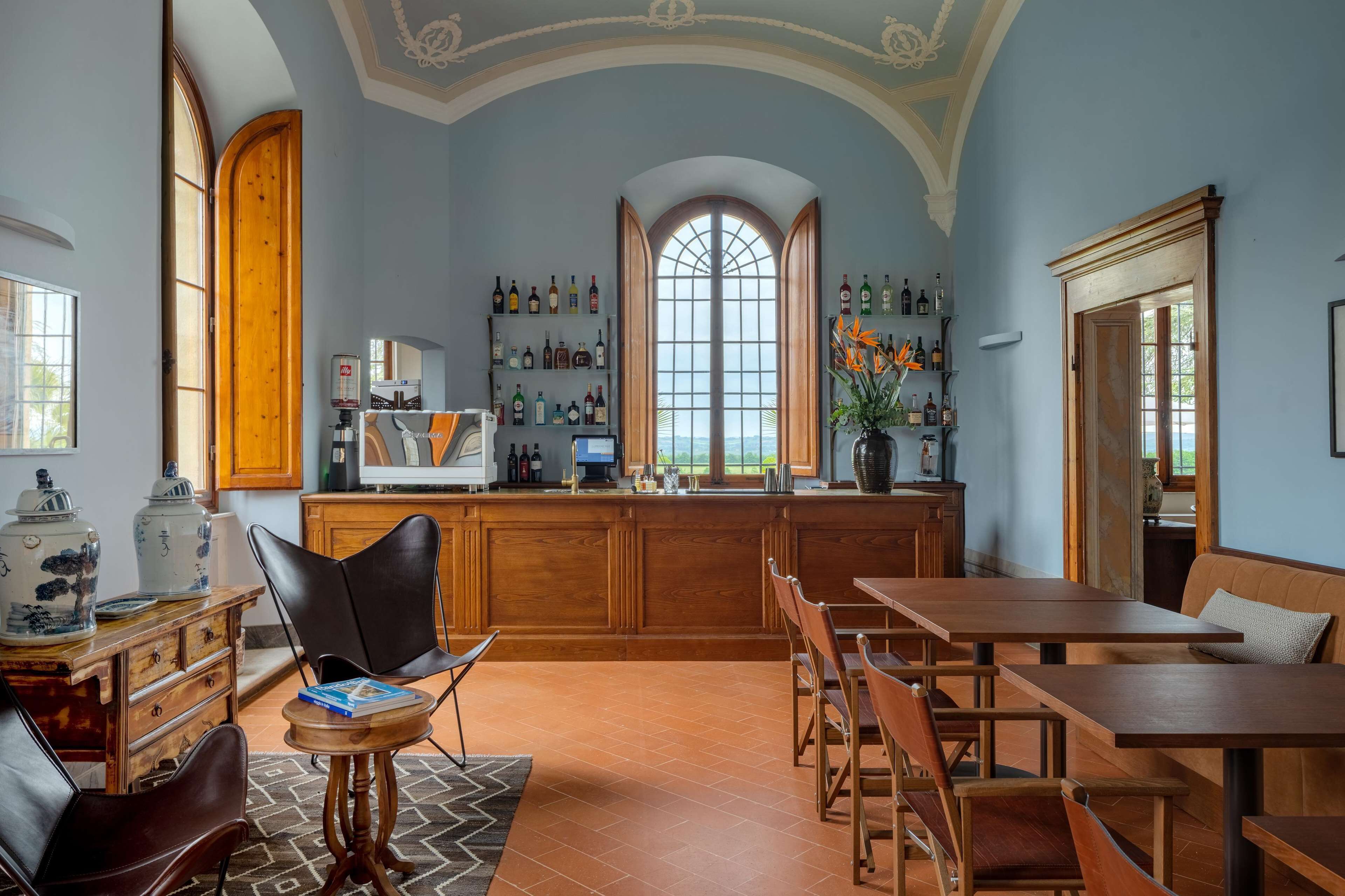 Eine geräumige Küche mit Holzausstattung, einem großen Fenster und einer Bar mit Flaschenregalen.