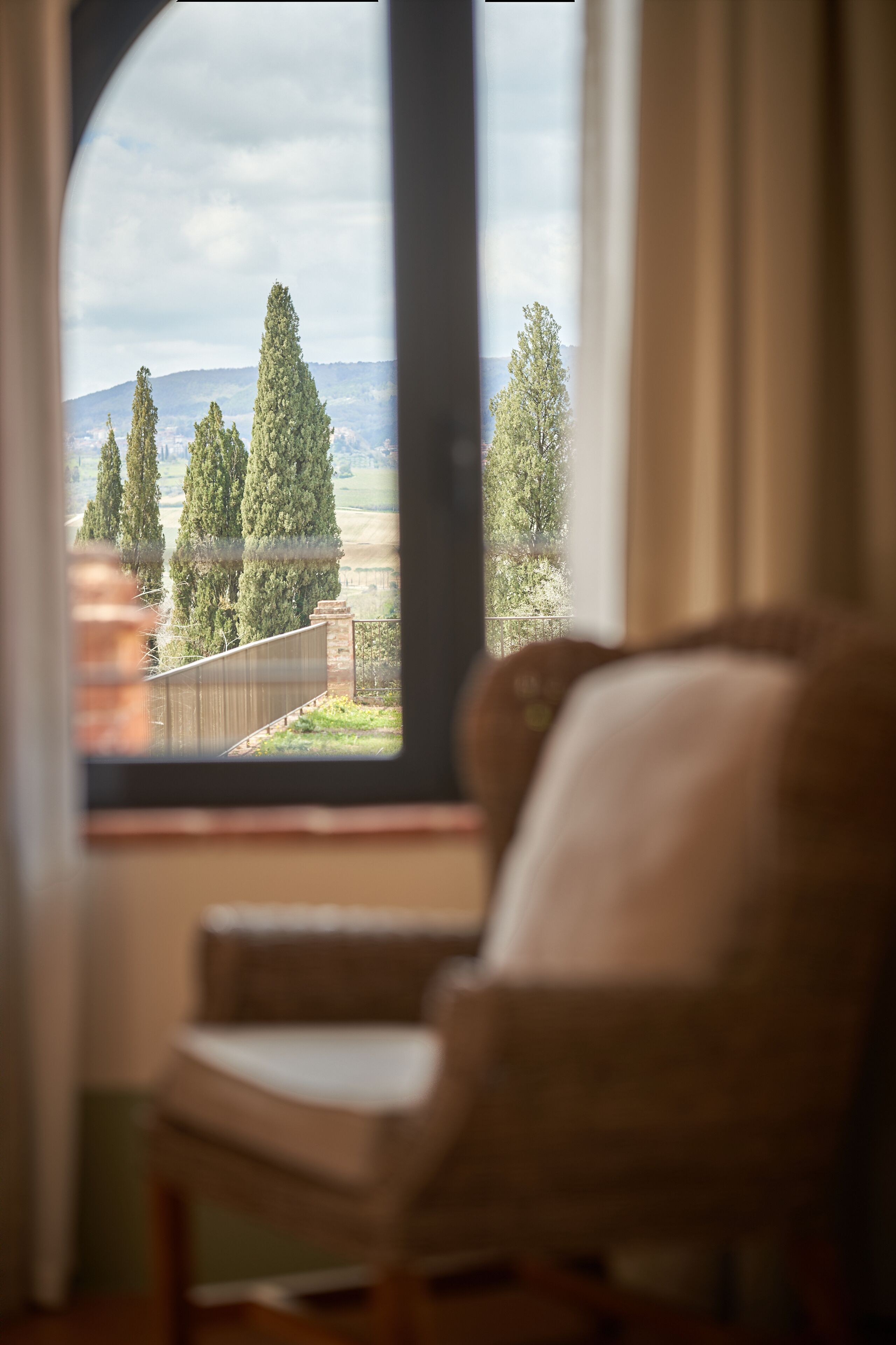 Una stanza con un'ampia finestra che si affaccia su alberi e un paesaggio lontano.