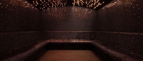 A room with a patterned tiled wall, a wooden floor, and a bench.