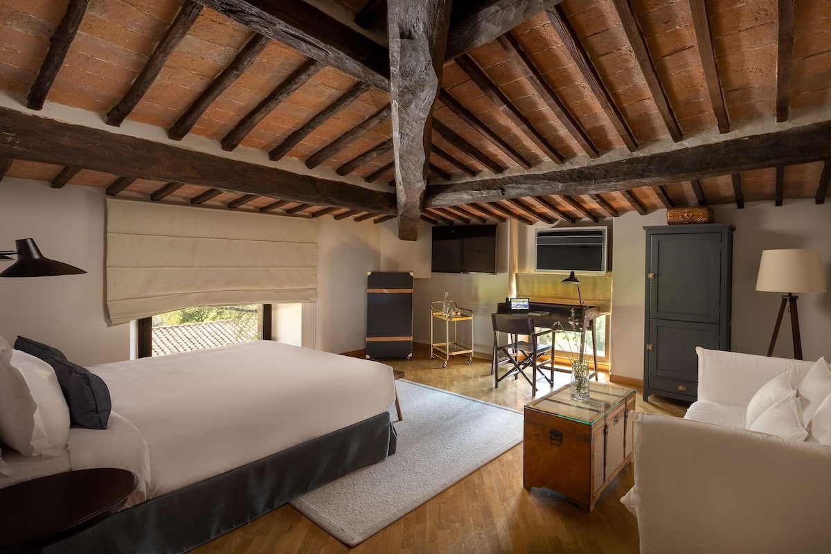 Ein Schlafzimmer mit einem großen Bett, einem Schreibtisch, einem Stuhl und einem Kleiderschrank.