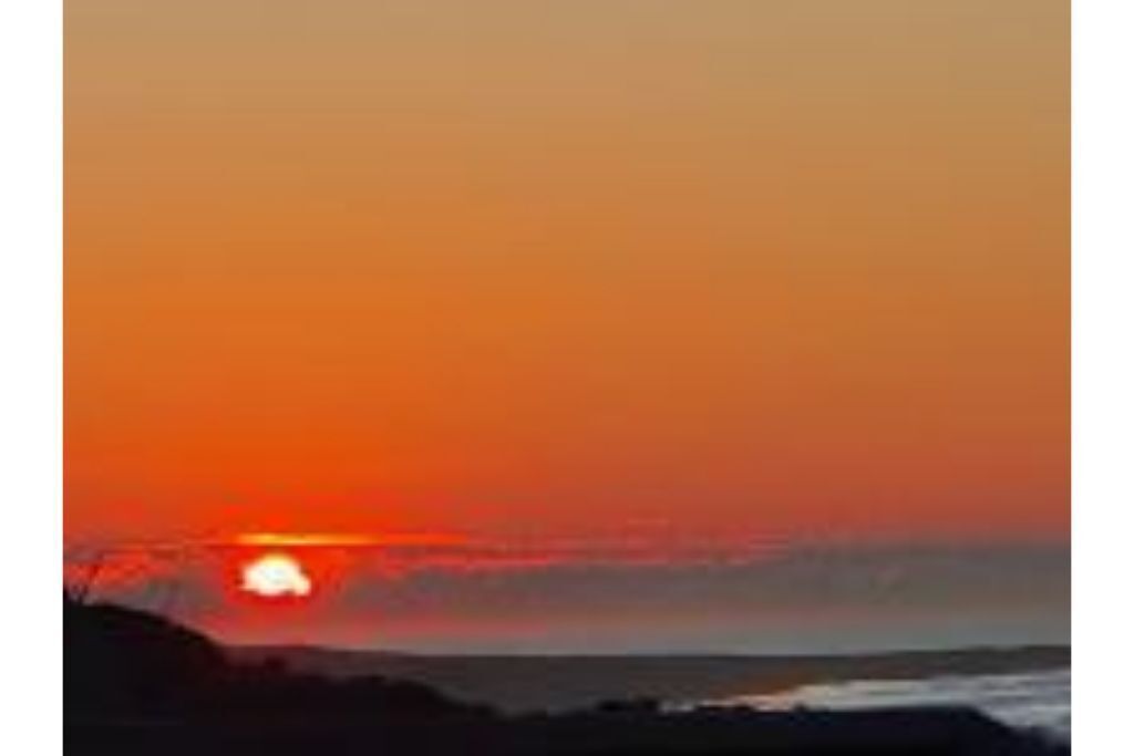 A sunset over a coastal landscape.