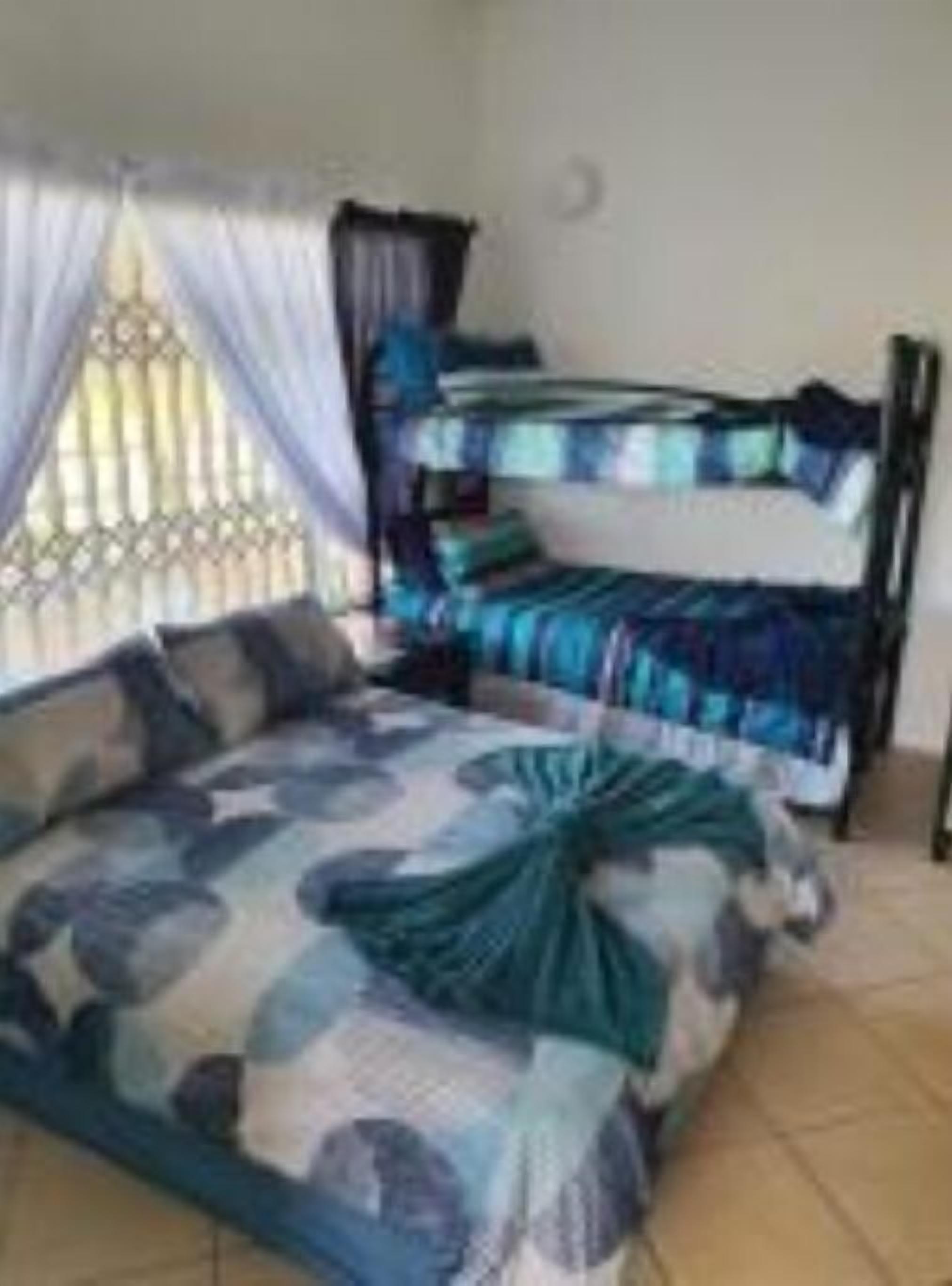 A room with a bed, a window with curtains, and a bed frame.