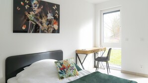 Ein Schlafzimmer mit einem Bett, einem Schreibtisch und einem Stuhl.
