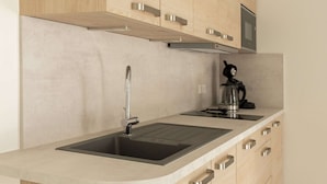 A modern kitchen with a built-in sink, stainless steel faucet, and wooden cabinets.