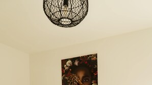 A bedroom with a bed, a small round table, and a wall-mounted artwork. - Comfort apartment no. 1 on the first floor on the right (street side, without terrace) (Dormagen)
