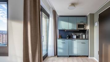 A modern kitchen with light blue cabinets, a microwave, and a sink.