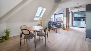 A modern loft apartment with a dining area, a sofa, and a kitchen. - Limehome Stuttgart Elsenhansstr. (Stuttgart)
