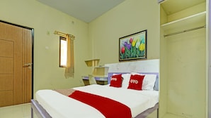 Une chambre à coucher avec un lit, une fenêtre avec des rideaux, un tableau au mur et une armoire.
