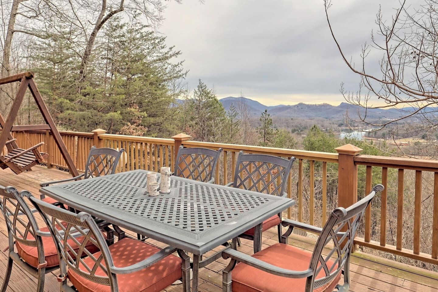 Una terraza con una mesa y sillas, con vistas a un paisaje montañoso.