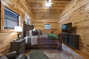 Cozy bedroom with a central bed, television, and wooden nightstand.