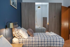 A bedroom with a bed, bedside tables, a lamp, and a wardrobe. - Rhome 14 Smart workers cozy apt (Rho)