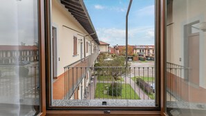 A balcony with a metal railing, a view of neighboring buildings, and a clear sky. - Rhome 14 Smart workers cozy apt (Rho)