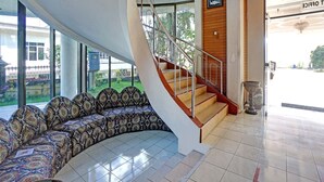 A modern interior with a curved seating area, a staircase, and a view of the outside.