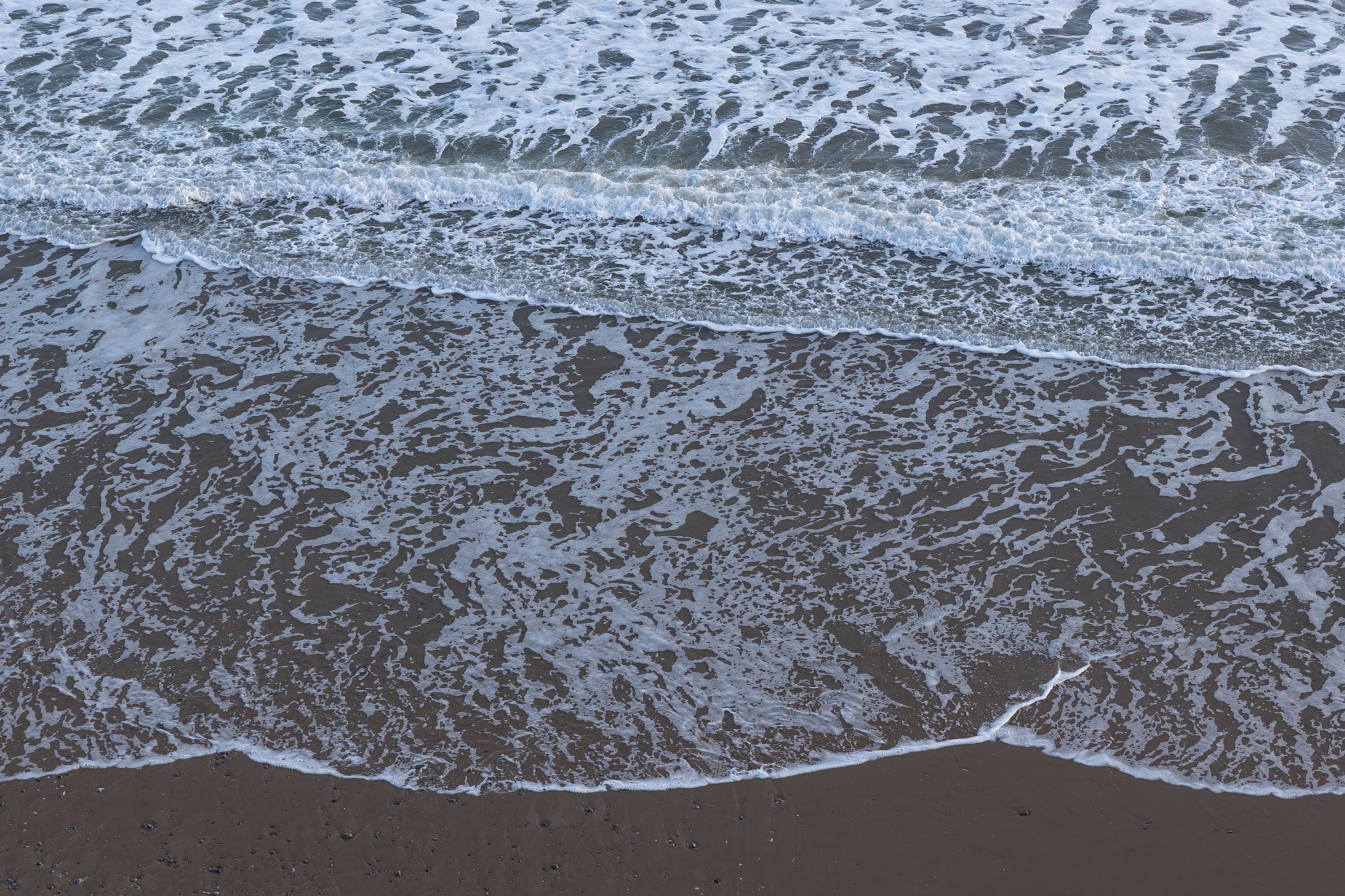 Una playa con olas que acarician suavemente la orilla.