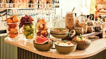 Un espace bar proposant une variété de produits alimentaires et de boissons, notamment des fruits, des bouteilles et des bocaux.