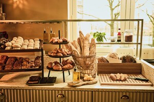 Eine Bäckertheke mit verschiedenen Backwaren und Blick durch ein Fenster.