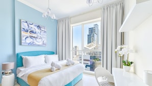 Una habitación de hotel moderna con una cama grande, un escritorio y vistas a la ciudad.