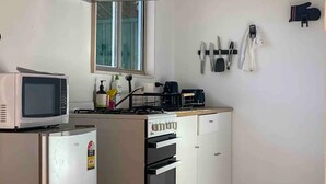Eine kleine Küche mit Mikrowelle, Toaster und Backofen.
