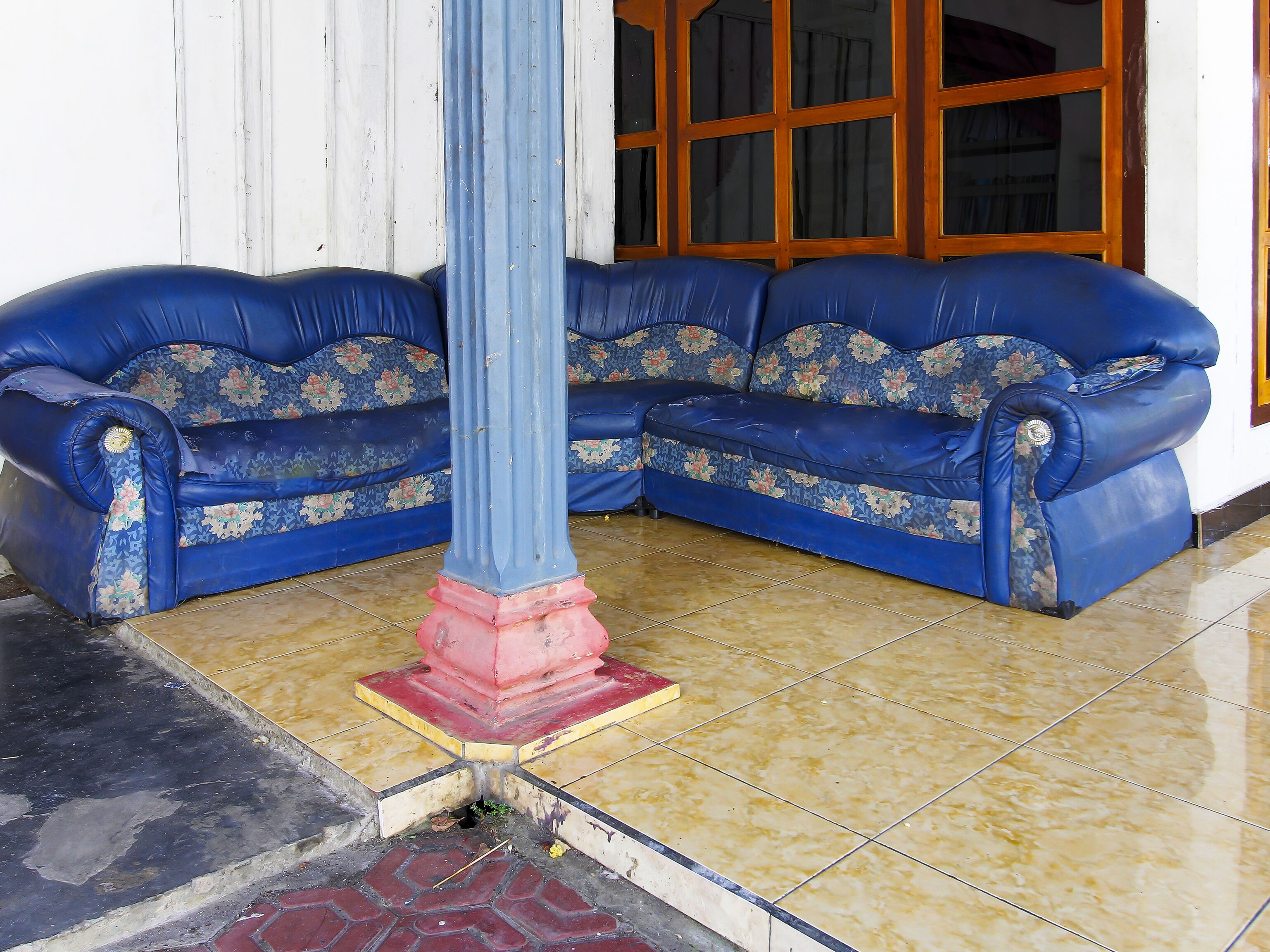 Un rincón amoblado con dos sofás azules y un pilar central.