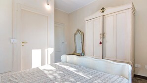 Ein Schlafzimmer mit einem Bett, einem Kleiderschrank und einem Spiegel.