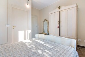 A bedroom with a bed, a wardrobe, and a mirror.