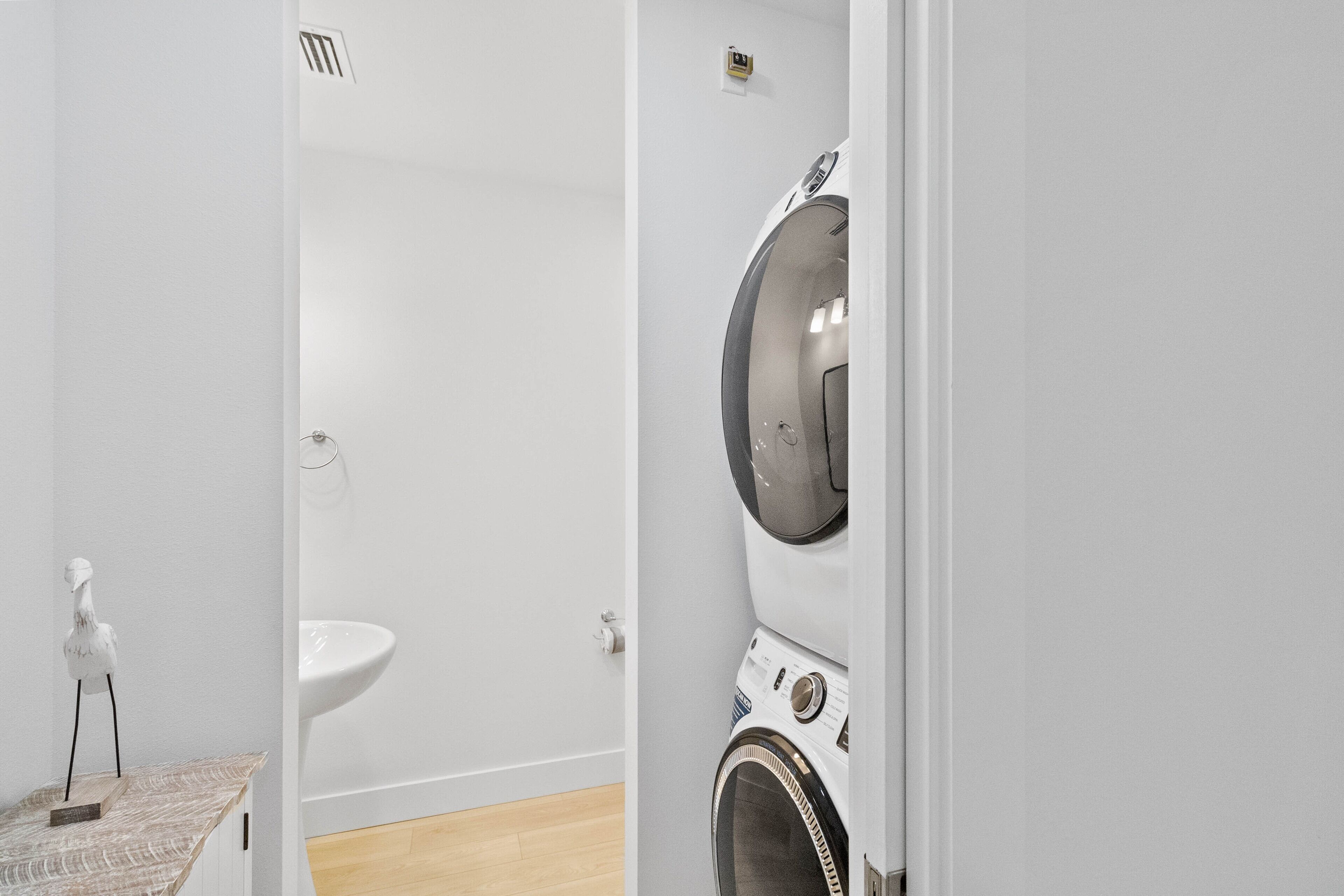 A laundry room with a washing machine and a sink.