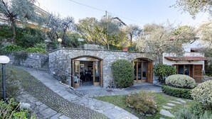A stone building with a courtyard, featuring a stone staircase, a wooden door, and a paved walkway. - Villa Renetta (San Massimo)
