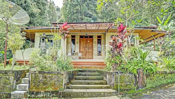 Una casa tradicional con puerta de madera, un pequeño porche y una antena parabólica.