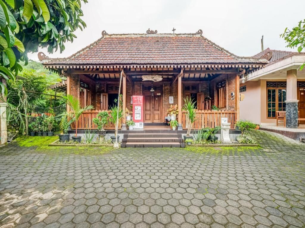 Il s’agit d’un bâtiment traditionnel, doté d’un toit en tuiles, d’un porche en bois et d’un escalier menant à l’entrée.