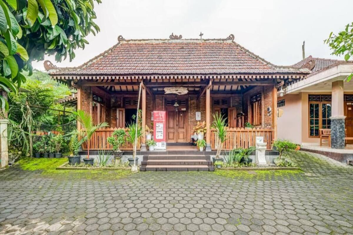 Il s’agit d’un bâtiment traditionnel, doté d’un toit en tuiles, d’un porche en bois et d’un escalier menant à l’entrée.