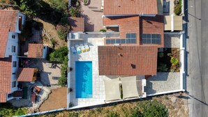 Vue aérienne d’un quartier résidentiel avec de nombreuses maisons, une piscine et des panneaux solaires.