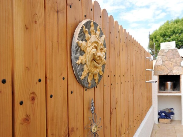 A wooden fence with a decorative metal sunburst and a metal flower-shaped ornament. - GERKENS: Holiday home with communal pool in l'Escala (L'Escala)