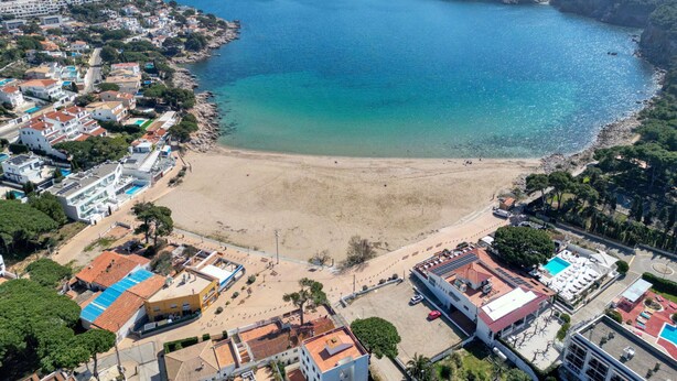 An aerial view of a coastal town with a sandy beach, residential buildings, and a clear view of the sea. - GERKENS: Holiday home with communal pool in l'Escala (L'Escala)