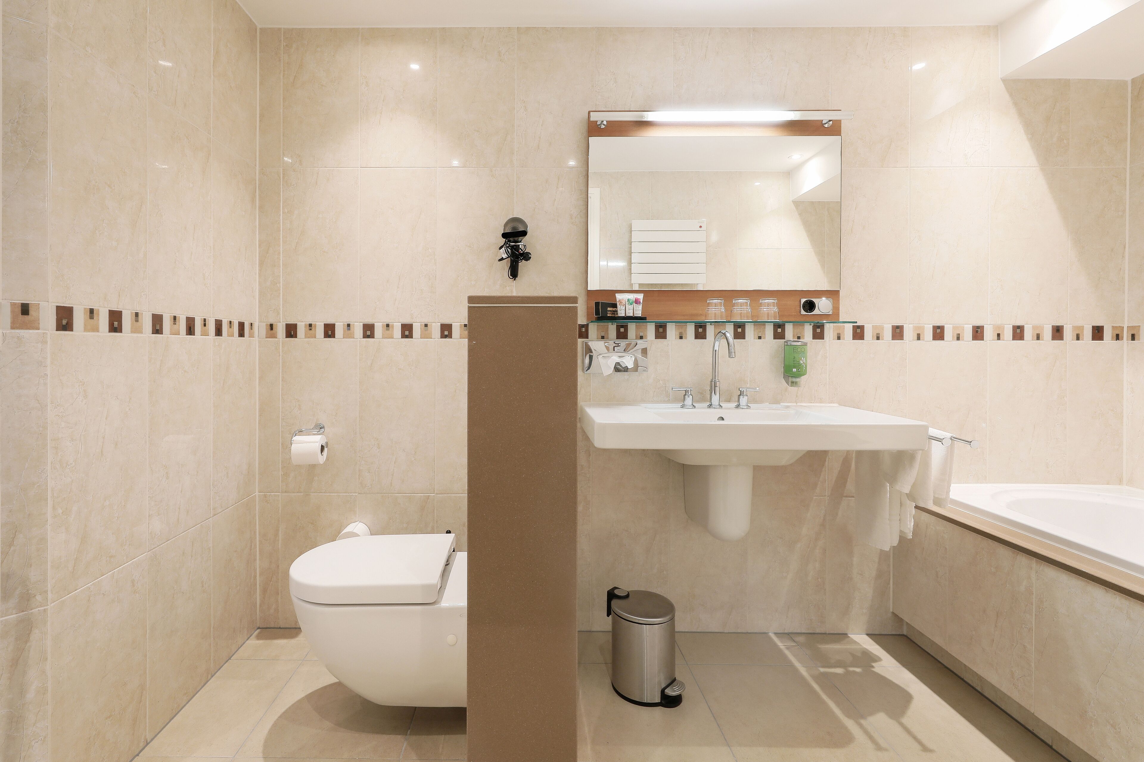 A modern bathroom with a toilet, sink, and bathtub.