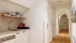Une cuisine moderne dotée d’une verrière, d’un plancher en bois et de meubles de rangement blancs.
