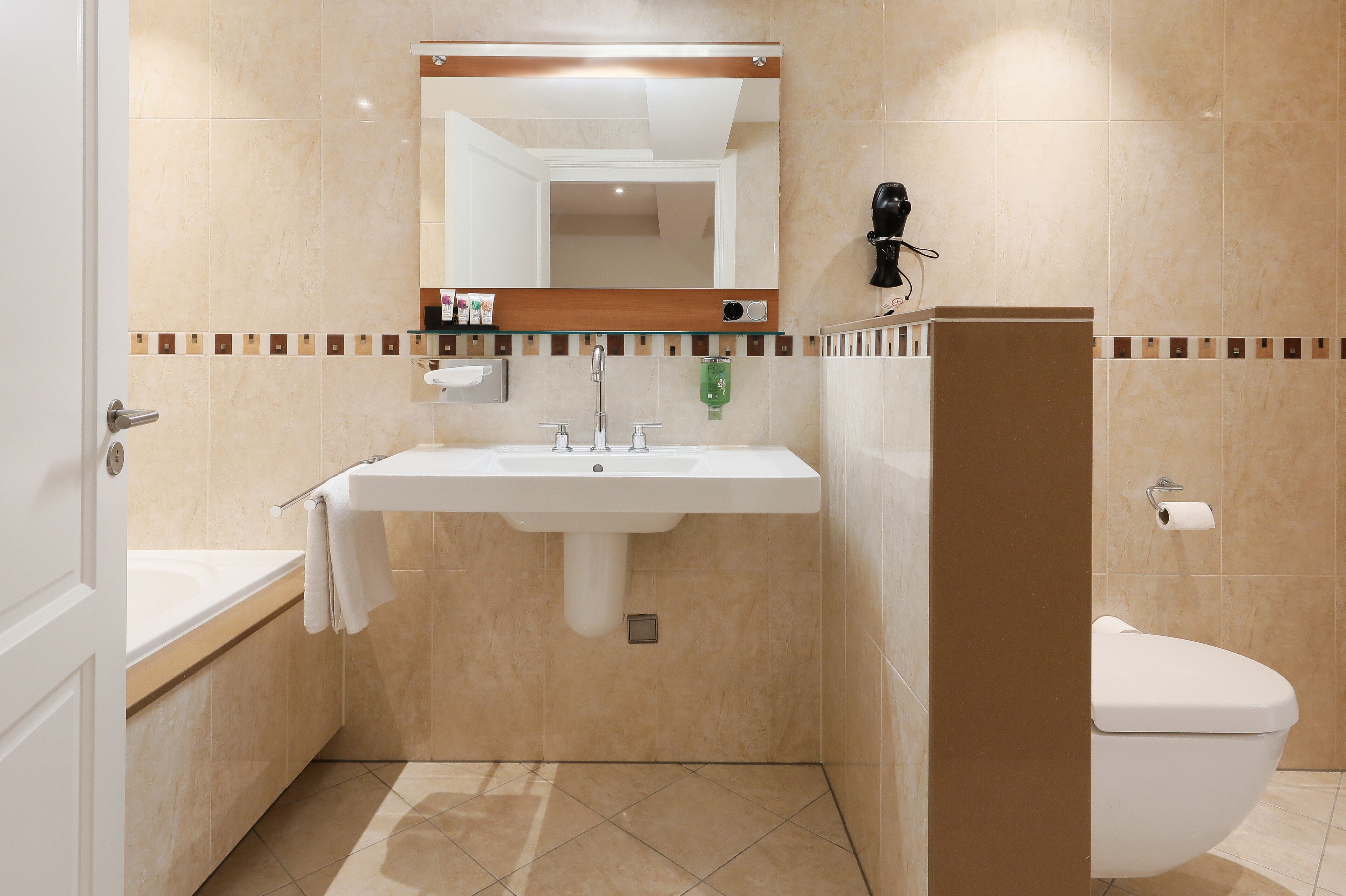 A bathroom with a sink, mirror, toilet, and towel rack.