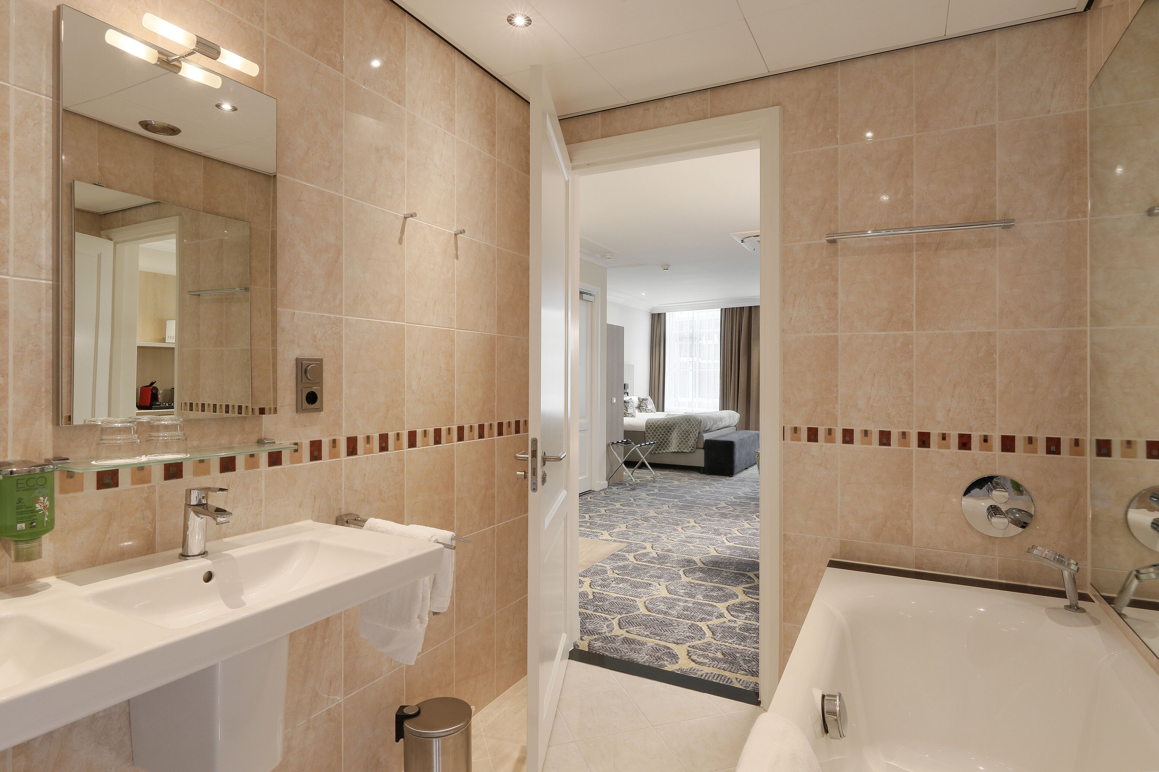 Ein modernes Badezimmer mit einem großen Waschbecken, einer Badewanne und einem Spiegel.