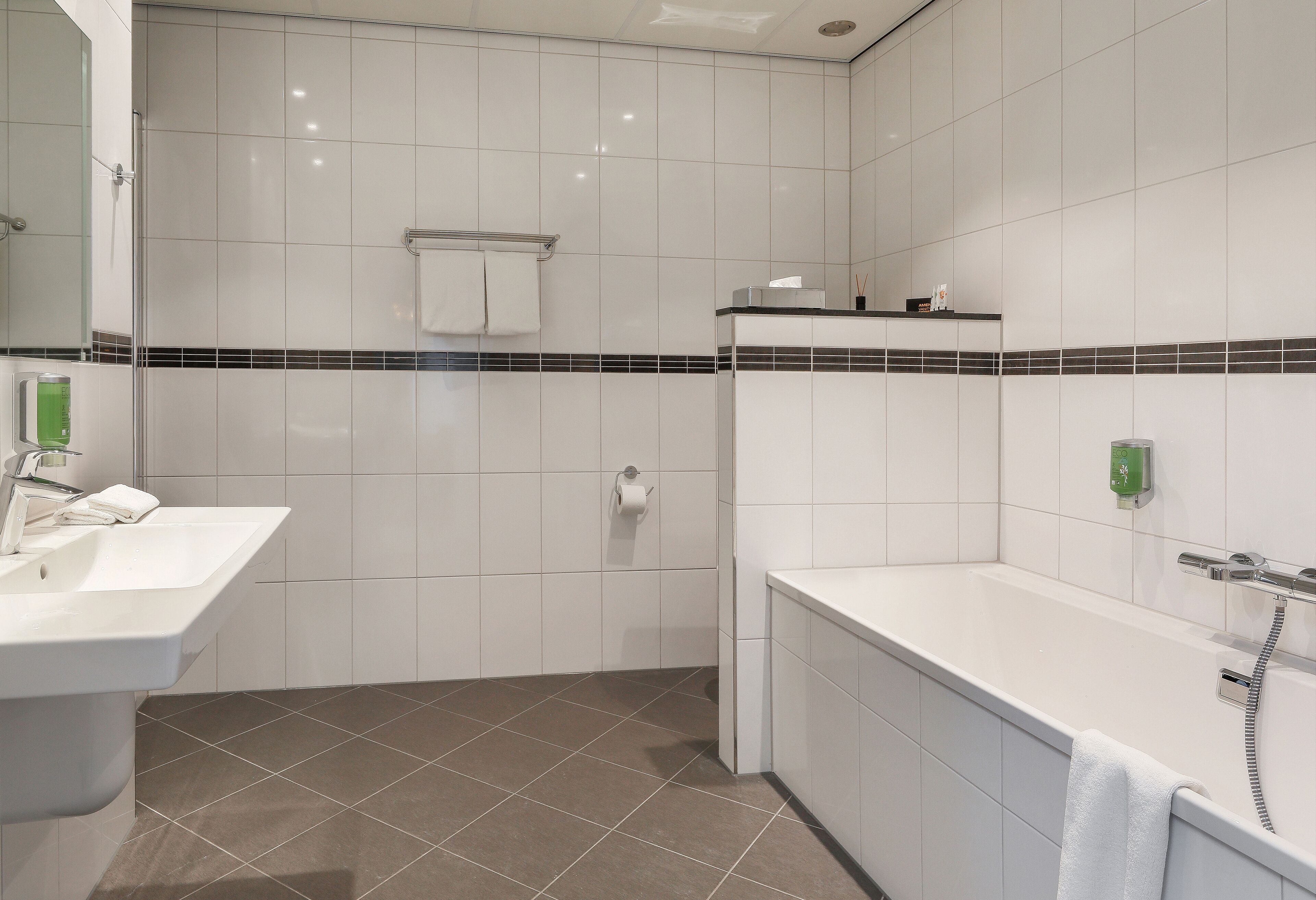 A modern bathroom with a sink, toilet, and bathtub.
