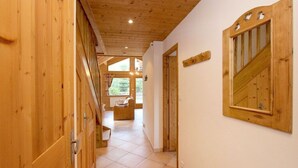 Ein Holzboden führt durch einen Flur mit Fliesen zu einem Zimmer mit Fenster.
