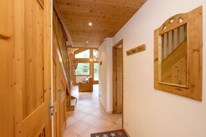 Ein Holzboden führt durch einen Flur mit Fliesen zu einem Zimmer mit Fenster.