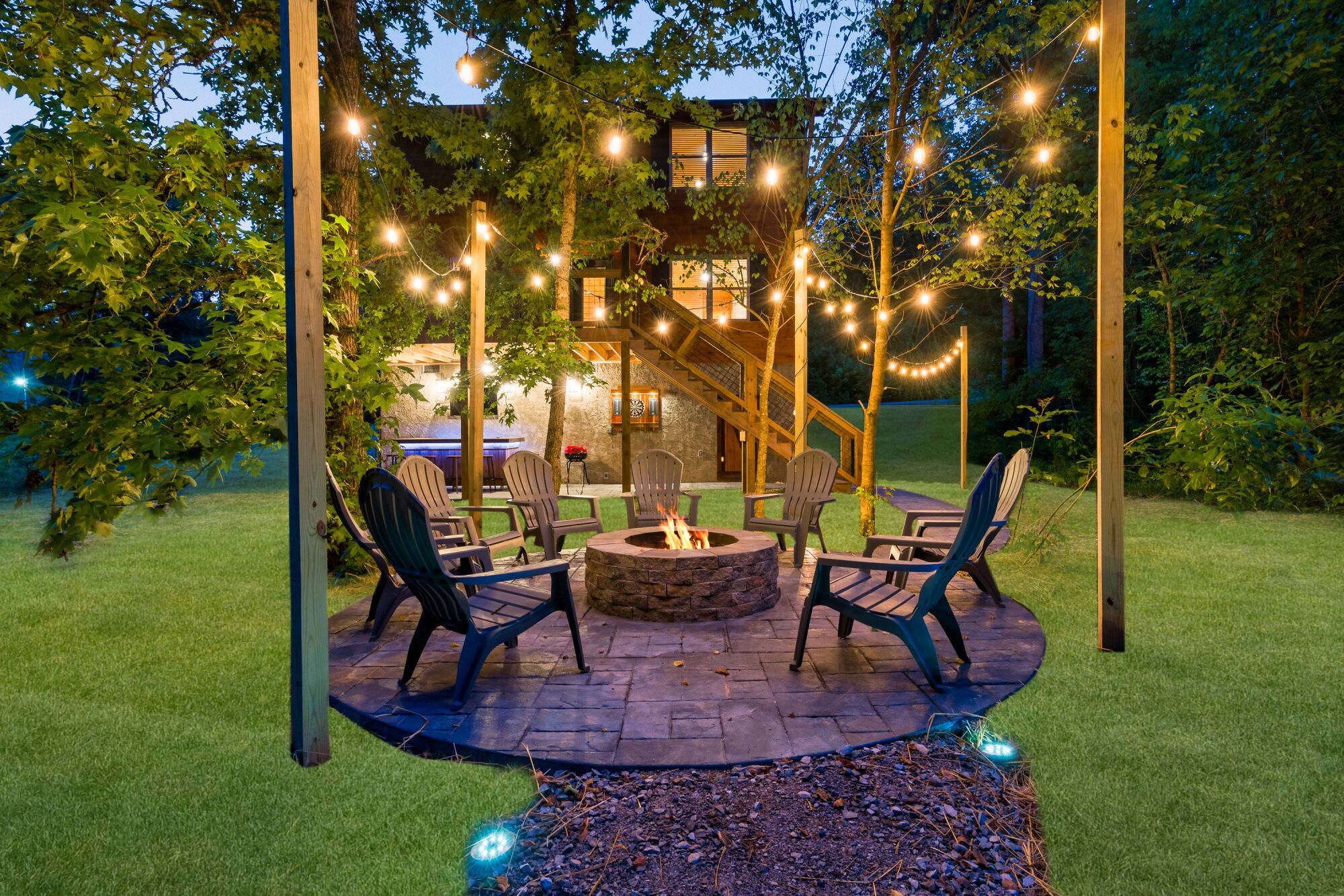 Eine Terrasse im Freien mit Feuerstelle, Sitzgelegenheiten und Lichterketten.