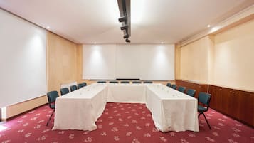 Une salle de conférence équipée d’une longue table, de chaises et d’un projecteur.