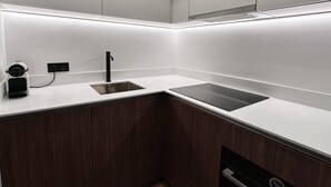 Una cucina moderna con lavello integrato, un rubinetto nero e un piano di lavoro elegante.