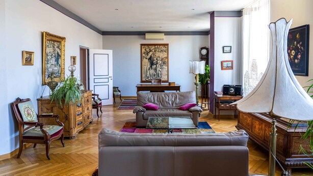A spacious living room with a leather sofa, wooden furniture, and a large painting on the wall. - Voltaire - Magnificent 4-bedroom duplex in Triangle d'Or (Bordeaux)