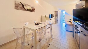 Een moderne keuken met een eethoek, een televisie en een boekenplank.